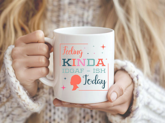 Person holding a mug with text 'Feeling kinda IDGAF-ish today' in a cozy setting.
