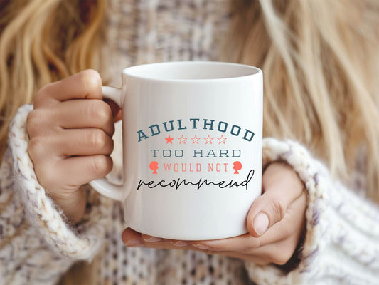 Person holding a mug with a humorous quote about adulthood