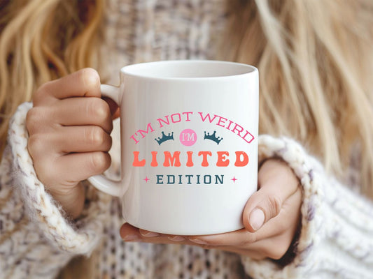 Person holding a mug with 'I'm not weird, I'm limited edition' text