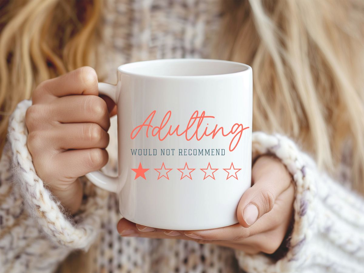 Person holding a white mug with 'Adulting would not recommend' text and star ratings.